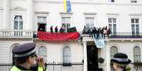 Polícias britânicos observam manifestação em casa de bilionário  Foto: Peter Nicholls / Reuters