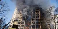 Bombeiros ucranianos combatem as chamas em um prédio residencial em Kiev  Foto: Thomas Peter / Reuters
