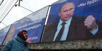 'A Rússia não começa guerras, acaba com elas', dizia um outdoor de Vladimir Putin em Simferopol, na Crimeia, em 10 de março  Foto: Getty Images / BBC News Brasil