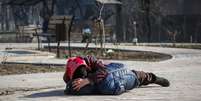 Mãe protege seu filho durante bombardeio em Mariupol  Foto: Alexander Ermochenko / Reuters