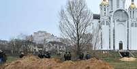 Uma vala comum foi encontrada fora de uma igreja em Bucha  Foto: Getty Images / BBC News Brasil