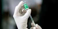 Funcionário da área da saúde extrai uma dose da vacina contra a Covid-19  Foto: Reuters