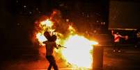 Um manifestante tenta apagar um incêndio em frente à sede do Supremo Tribunal Federal, em Lima, em 5/4  Foto: EPA / BBC News Brasil