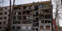 Dia 15/4 - Mulheres passam por pr&eacute;dio destru&iacute;do pela guerra na cidade de Kharkiv  Foto: Alkis Konstantinidis / Reuters