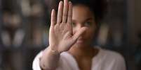 Imagem mostra uma mulher negra que está com a mão levantada  Foto: iStock / Alma Preta