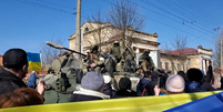 Ativistas pró-Ucrânia em frente a soldados russos durante uma manifestação em Kherson  Foto: BBC News Brasil