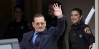 Johnny Depp acena para o público ao deixar o julgamento contra a ex-mulher, Amber Heard  Foto: Reuters