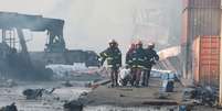 Bombeiros carregam corpo após um grande incêndio em um depósito de contêineres em Sitakunda, perto da cidade portuária de Chittagong, Bangladesh  Foto: Reuters