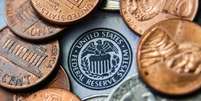 Dólares e símbolo do Federal Reserve  Foto: AFP / BBC News Brasil