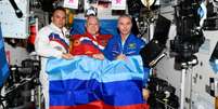 Cosmonautas russos Sergey Korsakov, Oleg Artemyev e Denis Matveev exibem bandeira da República Popular de Lugansk na ISS   Foto: Roscosmos/Telegram / Meio Bit