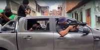 Imagem mostra um grupo armado dentro de um carro em clipe de pastor baiano  Foto: Reprodução/Redes sociais / Alma Preta