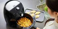 Mulher usando air fryer para fazer batata frita  Foto: Getty Images / BBC News Brasil