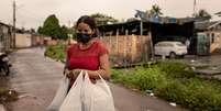 Maria Luiza segura doações de alimentos  Foto: Mariana Guerreiro - Visão Mundial / BBC News Brasil