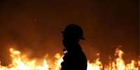 Brigadista durante incêndio  Foto: REUTERS/Bruno Kelly / BBC News Brasil