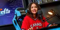 Foto mostra a streamer de games Taiane Silva, uma mulher negra que usa uma blusa vermelha com a palavra "Canadá".  Foto: Arquivo Pessoal/Taiane SIlva / Alma Preta