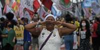 Imagem mostra mulher negra gritando em manifestação.  Foto: Imagem: Carl de Souza/AFP / Alma Preta