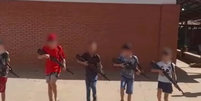 Crianças seguram réplicas de armas em escola  Foto: Reprodução/TV Globo