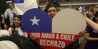 Homem com cartaz em forma de coração e as cores da bandeira do Chile onde se lê: 'Por amo ao Chile, rejeito'  Foto: EPA / BBC News Brasil