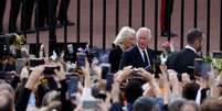 Rei Charles e Camilla Parker Bowles cumprimentam pessoas em frente ao Palácio de Buckingham    Foto: Reuters
