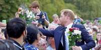 O príncipe Harry recebeu flores da multidão  Foto: POOL / BBC News Brasil