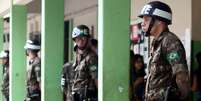 Soldados montam guarda enquanto as pessoas esperam na fila para votar em zona eleitoral no Rio de Janeiro em 28 de outubro de 2018  Foto: RICARDO MORAES/AFP via Getty Images / BBC News Brasil