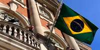 Com bandeira a meio mastro, Bolsonaro discursa a apoiadores na sacada da residência do embaixador em Londres  Foto: Laís Alegretti/BBC News Brasil / BBC News Brasil