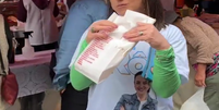 Rosângela Moro postou vídeo comendo pastel de feira e foi criticada na web por mulher aparecer atrás revirando lixo  Foto: Reprodução/Twitter