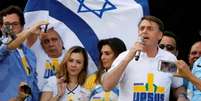 Fotografia colorida mostra Bolsonaro na Marcha para Jesus em frente a uma bandeira de Israel  Foto: Reuters / BBC News Brasil
