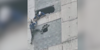 Trabalhador fica pendurado em prédio em obras em Guarujá  Foto: Reprodução