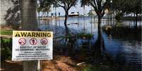Um sinal de aviso perto da inundação  Foto: Getty Images / BBC News Brasil
