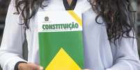 Florianópolis, Santa Catarina, Brazil - April 21, 2018: A close-up view of a woman holding the Constitution of the Federative Republic of Brazil book in Santa Catarina state, Brazil  Foto: Getty Images/Getty Images / Guia do Estudante