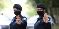 A foto mostra duas policiais com um x vermelho na mão, símbolo contra a violência doméstica  Foto: Imagem: Divulgação/Aluno Sargento Picanço e Soldado Jordan / Alma Preta