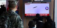 Pessoas assistem a uma reportagem na TV que mostra a Coreia do Norte disparando mísseis balísticos no mar, em Seul, na Coreia do Sul, em 2 de novembro de 2022  Foto: YONHAP/REUTERS / BBC News Brasil