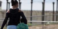 Imagem mostra mãe negra com o filho a caminho da visita em presídio, como fazem muitas mulheres negras, as principais vítimas de constrangimentos.  Foto: Imagem: Jorge William/O Globo / Alma Preta