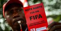 Manifestante dá "cartão vermelho" para a Fifa  Foto: Getty Images / BBC News Brasil