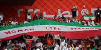 Torcedores do Irã levam bandeira com os dizeres "mulher, vida e liberdade" (AFP)  Foto: Lance!