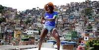 Imagem mostra mulher negra com uma camisa azul do Brasil, utilizada na Copa de 2022.  Foto: Imagem: Caio Oliveira / Alma Preta