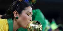 Torcedora brasileira beija réplica da taça da Fifa em partida entre Brasil e Suíça  Foto: Carl Recine