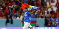 Torcedor invade campo com bandeira LGBTQIA+ e camisa pedindo respeito às mulheres iranianas e para salvarem a Ucrânia  Foto: Reuters