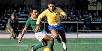 Imagem mostra Garrincha, com o uniforme da Seleção Brasileira, driblando adversário.  Foto: Imagem: Reprodução / Alma Preta