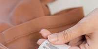 Nunca esqueça de conferir a etiqueta das roupas antes de lavá-las –  Foto: Shutterstock / Alto Astral