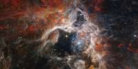 A Nebulosa da Tarântula, localizada a apenas 161 mil anos-luz da Terra, é um lugar onde nascem milhares de estrelas  Foto: NASA/ESA/CSA/STScI/Webb ERO Production Team / BBC News Brasil