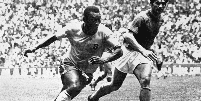 Na imagem, Pelé, um jogador negro, driblando durante um jogo de futebol Tarcisio Burgnich, jogador branco. Foto em preto e branco, estão em um estádio de futebol, na final da Copa de 1970, no México.  Foto: Imagem: STAFF/AFP / Alma Preta