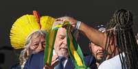 A catadora de recicláveis Aline Souza coloca a faixa no presidente Lula   Foto: Ricardo Stuckert/Divulgação