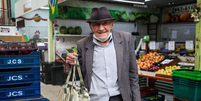 Seu João Leiva, de 82 anos, compra alguns legumes e frutas no mercado.  Foto: FOTO TIAGO QUEIROZ/ESTADÃO 