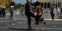 Imagem mostra manifestante negro sendo agredido por policial em manifestação contra o governo Temer, em 2017.  Foto: Imagem: Fernando Bizerra Jr./EPA / Alma Preta