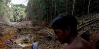 Yanomami segue agentes ambientais em uma mina de ouro durante operação contra o garimpo ilegal, em 2016  Foto:  Bruno Kelly/Reuters