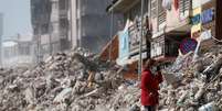 Mulher observa destroços do que costumava a ser sua casa em cidade da Turquia  Foto: Benoit Tessier