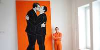 Ermira Murati posa ao lado de pintura que mostra o primeiro-ministro de Kosovo, Albin Kurti, e o presidente s&eacute;rvio, Aleksandar Vucic, se beijando  Foto: Reuters