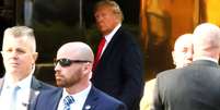 O ex  Foto: presidente Donald Trump em frente à Trump Tower, hoje à tarde, em Nova York; amanhã ele terá a 1ª audiência na justiça (Crédito  Michael M. Santiago/Getty Images) / Perfil Brasil